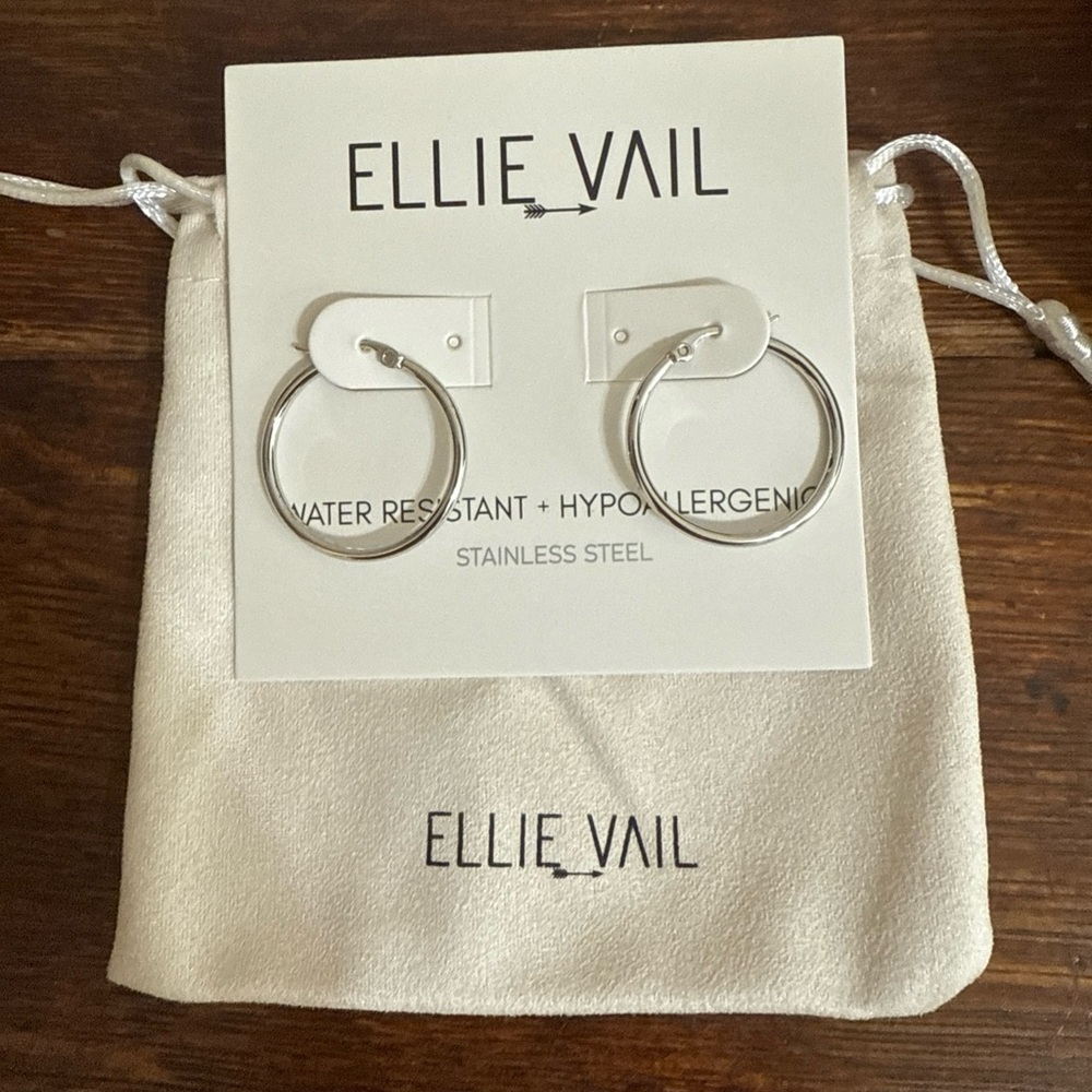 Silver toned hoop earrings by Ellie Vail. 1” diameter with snap closure.